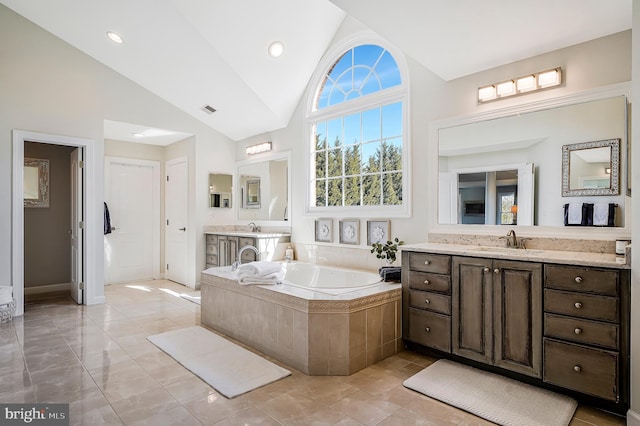 full bathroom featuring high vaulted ceiling, visible vents, vanity, and a bath