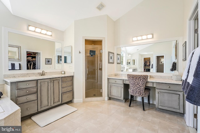 bathroom with lofted ceiling, a stall shower, a spacious closet, and vanity