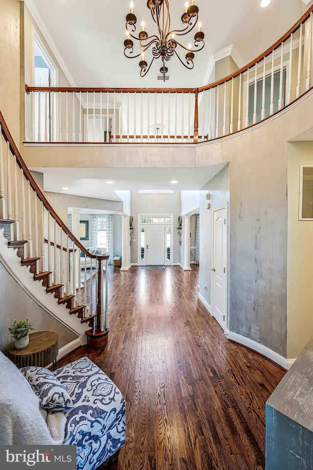 foyer entrance with stairs, baseboards, wood finished floors, and crown molding