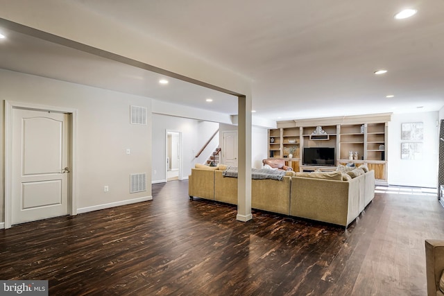 living room with dark wood finished floors, visible vents, and recessed lighting