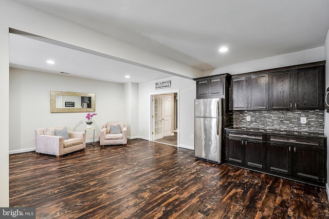 kitchen featuring freestanding refrigerator, dark wood-style flooring, baseboards, and decorative backsplash