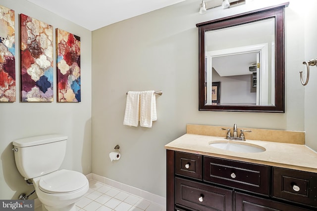 bathroom featuring toilet, tile patterned flooring, vanity, and baseboards