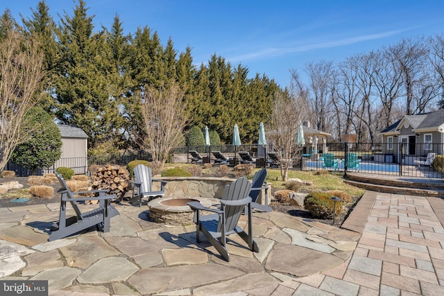 view of patio with an outdoor fire pit and fence