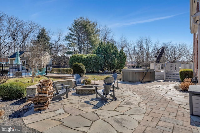 view of patio / terrace featuring a fire pit, a hot tub, fence, and a wooden deck