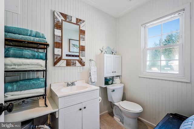 bathroom with tile patterned flooring, baseboards, vanity, and toilet