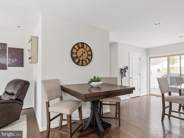 dining space with baseboards, wood finished floors, and recessed lighting