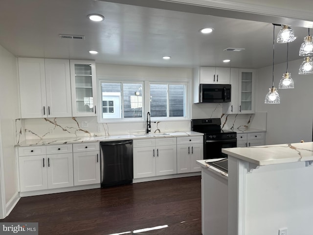 kitchen with white cabinets, dark wood finished floors, glass insert cabinets, black appliances, and a sink