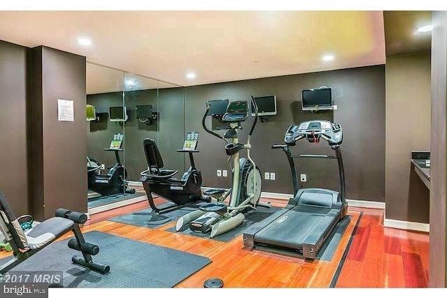 workout area featuring baseboards and wood finished floors