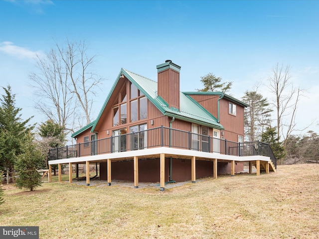 rear view of house featuring a deck, metal roof, and a yard