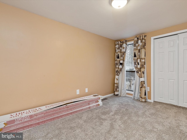 interior space with a closet, carpet, and baseboards