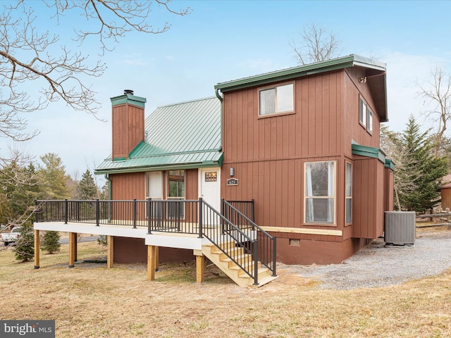 back of house with a chimney, a lawn, central AC unit, crawl space, and metal roof