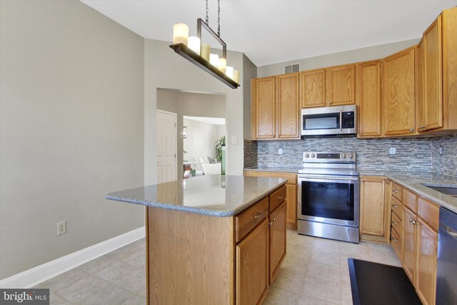 kitchen featuring light stone counters, visible vents, appliances with stainless steel finishes, and decorative backsplash