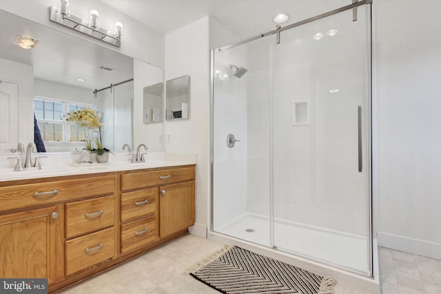 full bath featuring a shower stall, double vanity, visible vents, and a sink