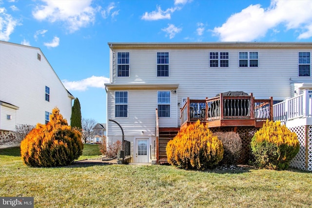 back of property featuring a lawn and a deck