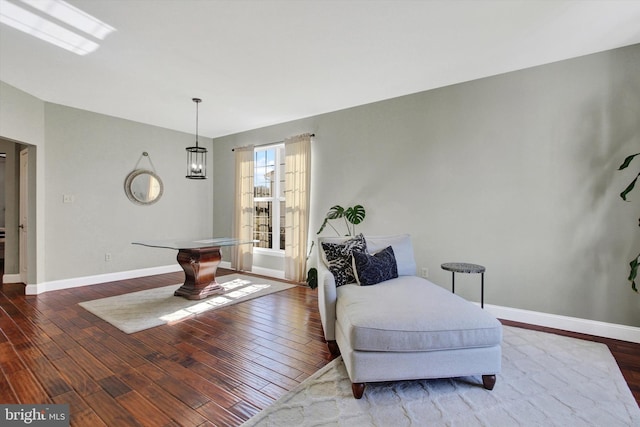 living area featuring baseboards and hardwood / wood-style flooring