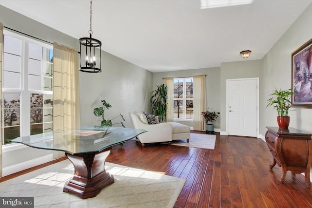 interior space featuring baseboards, wood-type flooring, and a chandelier