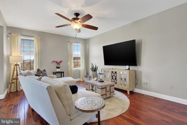 living room with dark wood finished floors, visible vents, baseboards, and ceiling fan