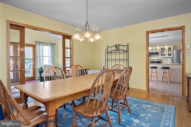 dining room featuring an inviting chandelier, baseboards, and wood finished floors