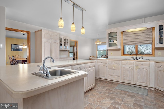 kitchen with glass insert cabinets, light countertops, and a sink