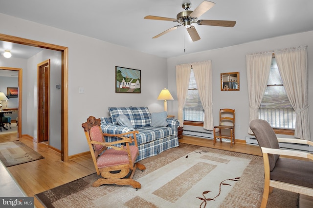 living room featuring wood finished floors, a ceiling fan, and baseboards