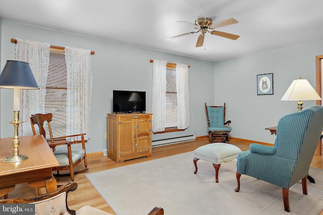 sitting room with a ceiling fan, baseboards, light wood finished floors, and baseboard heating