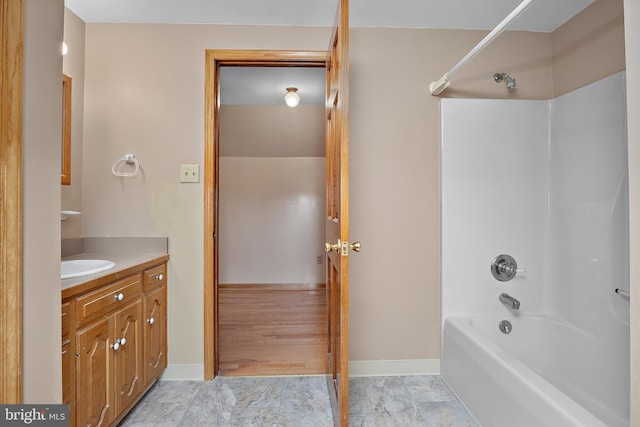 bathroom featuring vanity, baseboards, and shower / bathing tub combination