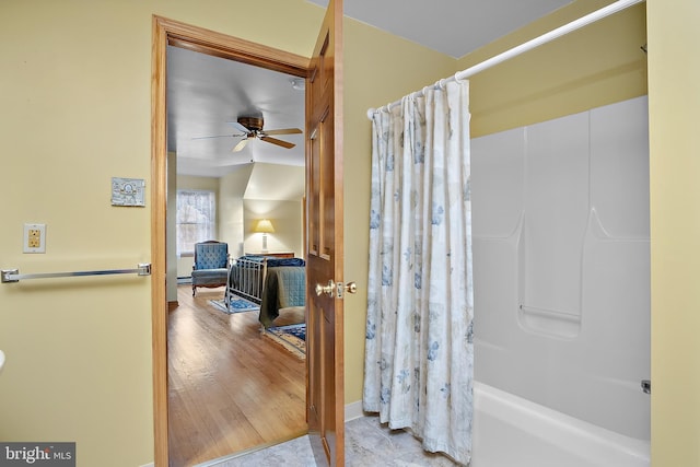 full bathroom featuring ceiling fan, wood finished floors, and shower / bathtub combination with curtain