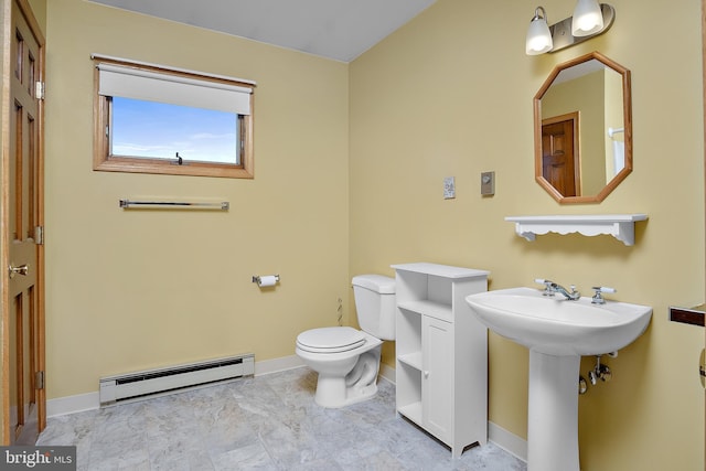 bathroom featuring baseboard heating, toilet, and baseboards