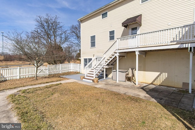 back of property featuring stairs, a patio area, fence, and a lawn