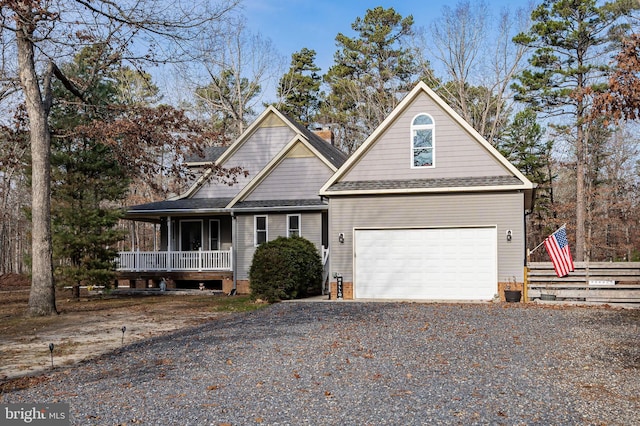 view of front of property with a shingled roof, gravel driveway, covered porch, and a garage