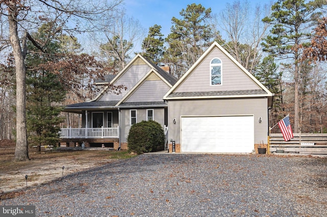 view of front of home with gravel driveway, covered porch, a shingled roof, and an attached garage