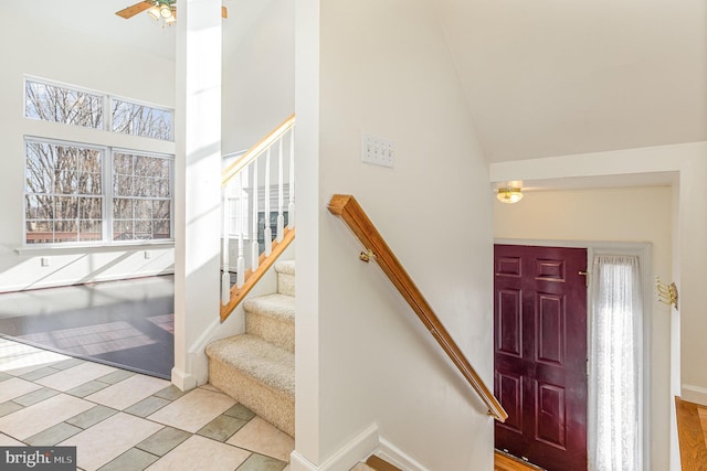 entryway featuring high vaulted ceiling, baseboards, stairway, and ceiling fan