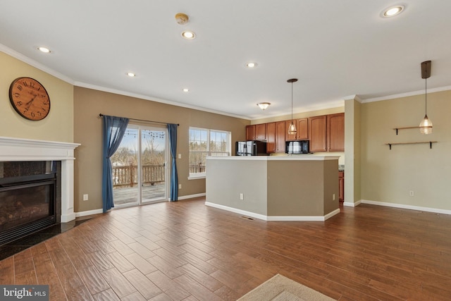 kitchen featuring dark wood-style flooring, black microwave, a tiled fireplace, and fridge