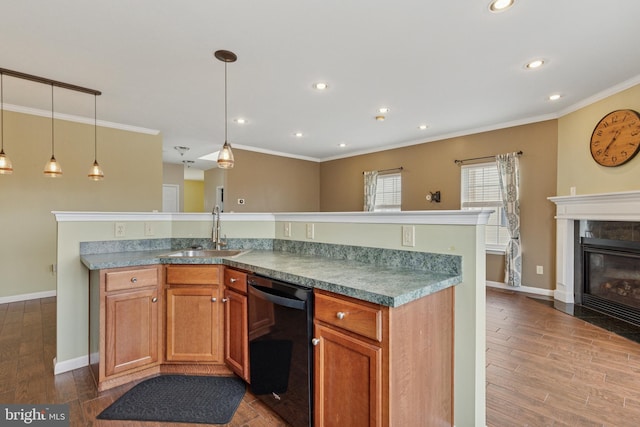 kitchen with black dishwasher, wood finished floors, crown molding, a fireplace, and a sink