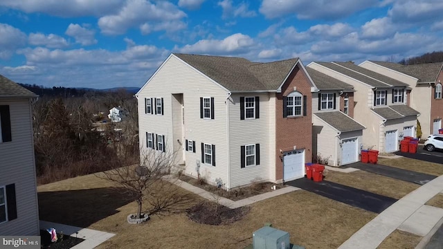 view of front of property featuring a garage, a residential view, driveway, and a shingled roof