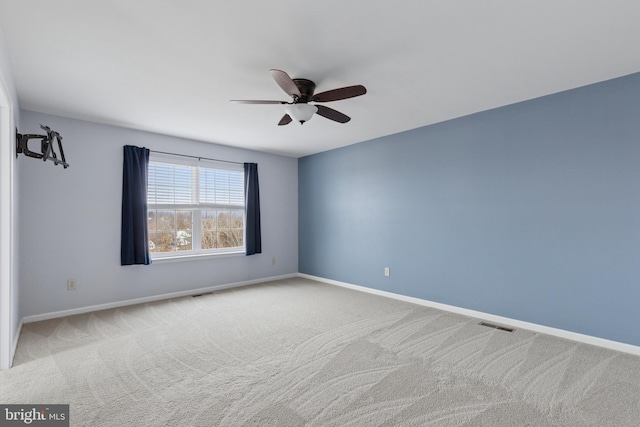 unfurnished room with a ceiling fan, carpet flooring, visible vents, and baseboards