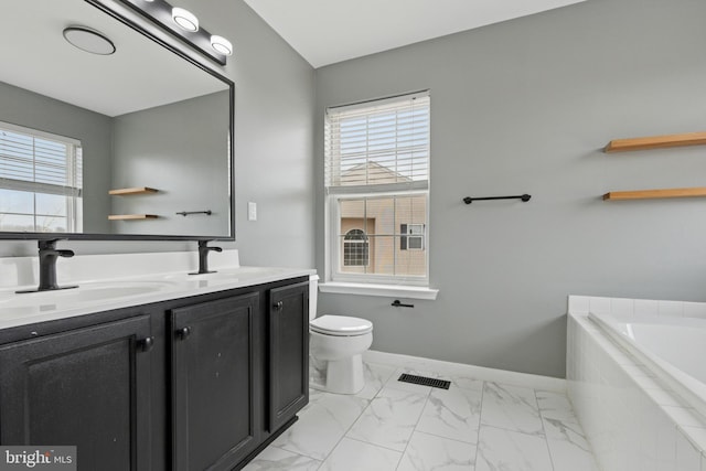 bathroom with plenty of natural light, marble finish floor, and a sink