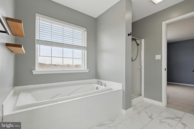 full bath with a stall shower, marble finish floor, baseboards, and a bath