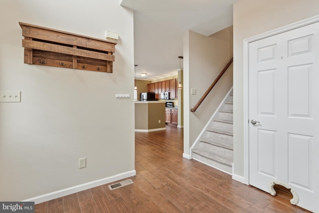 interior space featuring baseboards, stairs, visible vents, and dark wood-type flooring