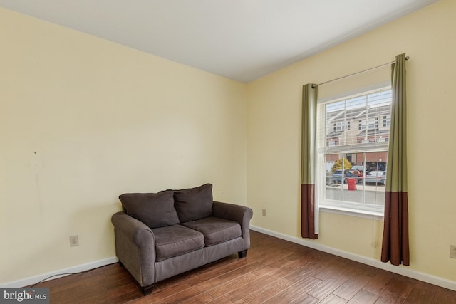 sitting room with baseboards and wood finished floors