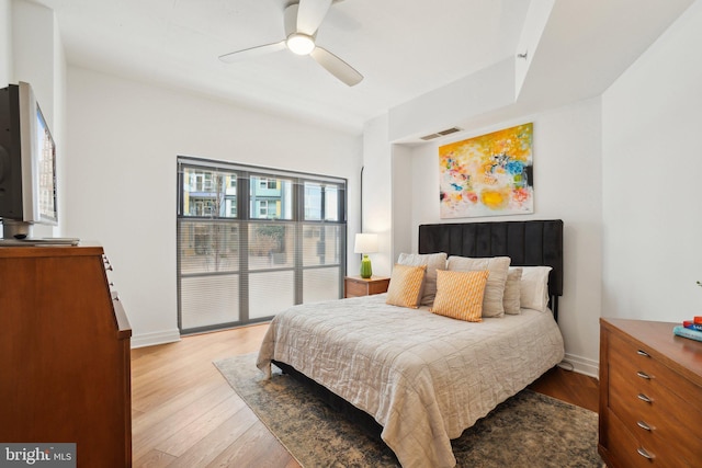 bedroom featuring light wood-style flooring, visible vents, ceiling fan, and baseboards