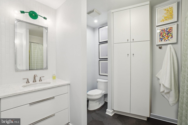 bathroom featuring toilet, visible vents, and vanity