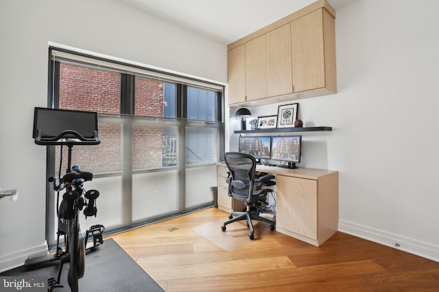 office area featuring baseboards and wood finished floors