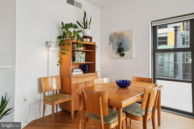 dining space with light wood-style floors and visible vents