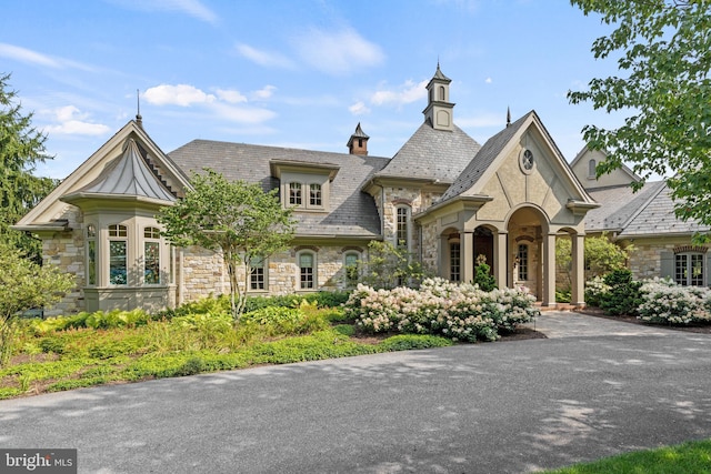 view of front of home featuring stone siding and a high end roof