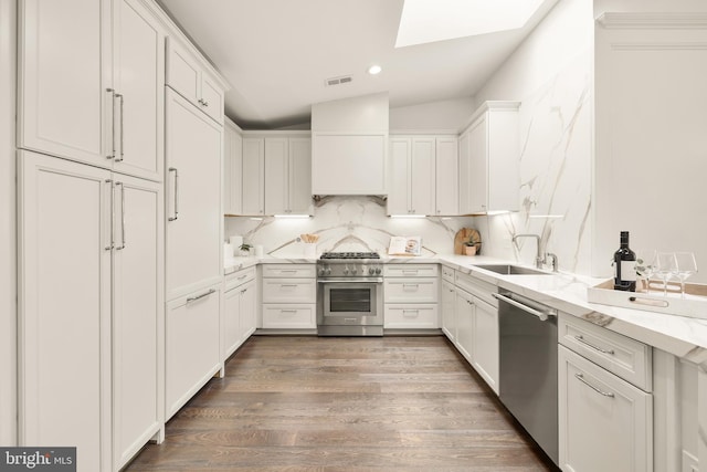kitchen with white cabinets, visible vents, custom exhaust hood, a sink, and stainless steel appliances