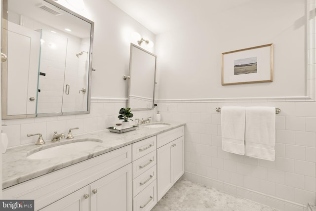 full bath featuring a shower stall, double vanity, visible vents, and a sink