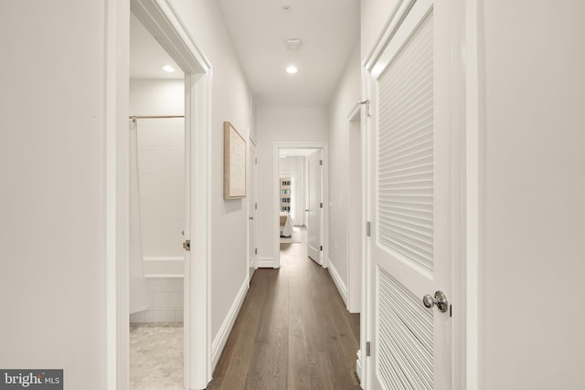 hallway featuring baseboards, recessed lighting, and dark wood-style floors