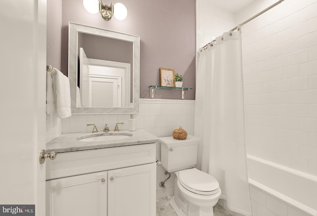 full bathroom with tile walls, toilet, shower / bathtub combination with curtain, and vanity