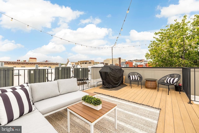 wooden deck with a grill and an outdoor hangout area